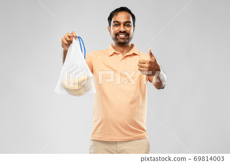 happy man holding reusable string bag with bananas 69814003
