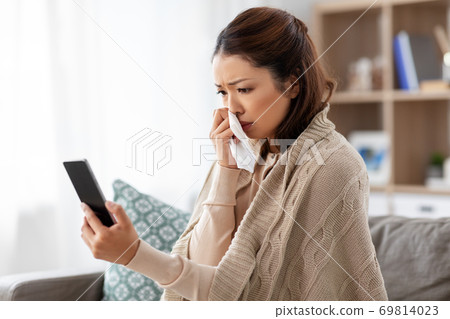 sick asian woman with smartphone at home sick asian woman with smartphone at home 69814023