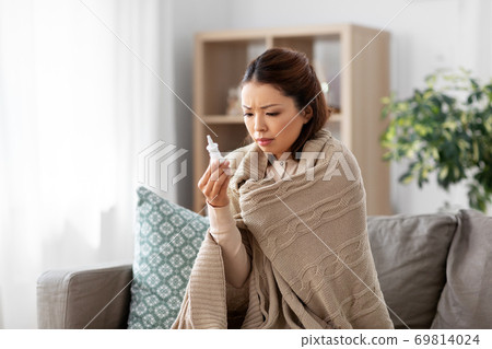 sick asian woman with nasal spray medicine at home sick asian woman with nasal spray medicine at home 69814024