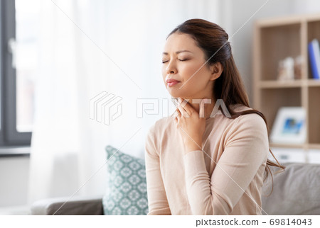 sick asian woman with sore throat at home 69814043