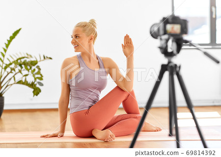 woman with camera streaming for yoga blog at home 69814392