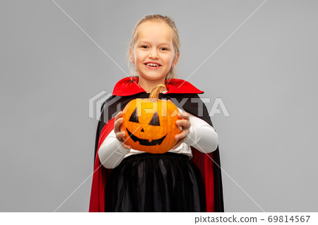 girl in halloween costume of dracula with pumpkin 69814567