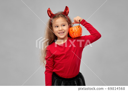 girl in halloween costume with jack-o-lantern 69814568
