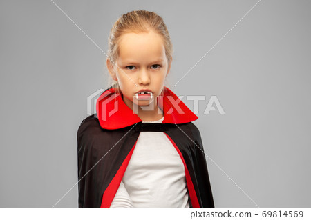 girl in dracula costume with cape on halloween 69814569