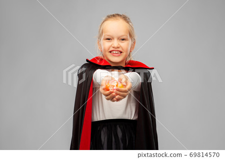girl in halloween costume of dracula with candies 69814570