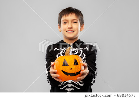 boy in halloween costume of skeleton with pumpkin 69814575