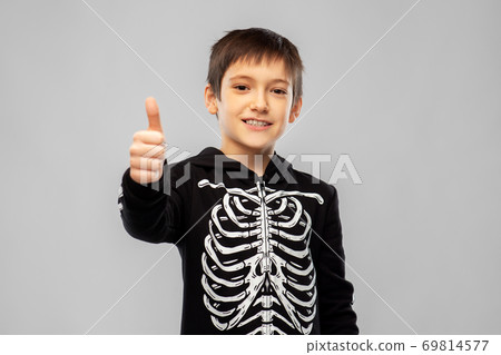 boy in halloween skeleton costume shows thumbs up boy in halloween skeleton costume shows thumbs up 69814577