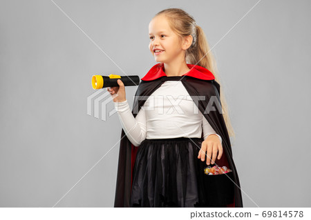 girl in halloween costume of dracula with candies 69814578
