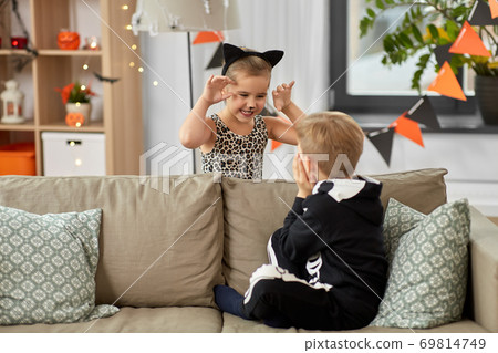 kids in halloween costumes playing at home 69814749