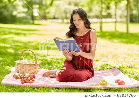 happy woman reading book at picnic in summer park happy woman reading book at picnic in summer park 69814760