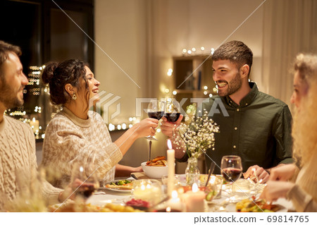 happy friends drinking red wine at christmas party happy friends drinking red wine at christmas party 69814765