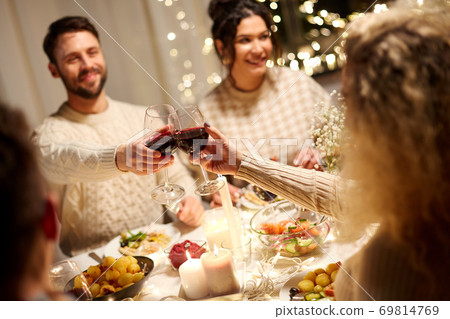 happy friends drinking red wine at christmas party happy friends drinking red wine at christmas party 69814769