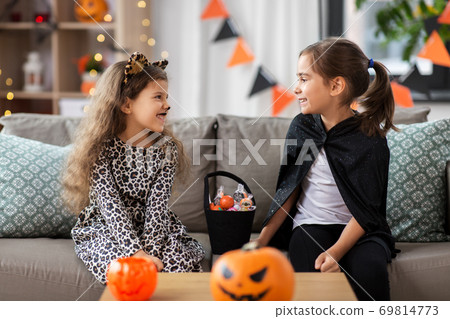 girls in halloween costumes with candies at home girls in halloween costumes with candies at home 69814773
