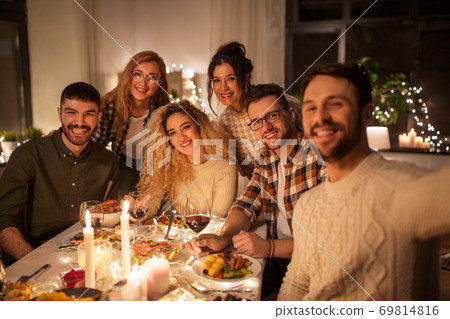 friends taking selfie at christmas dinner party 69814816