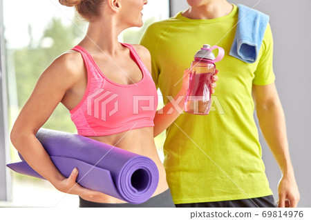 couple with water bottle, mat and towel in gym 69814976