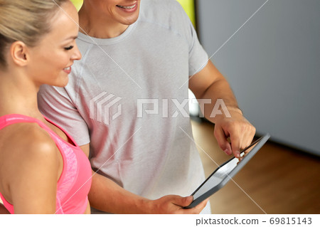 close up of man and woman with tablet pc in gym close up of man and woman with tablet pc in gym 69815143