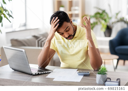 man with calculator and papers working at home 69815161