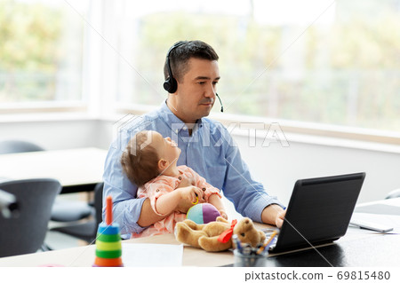 father with baby working on laptop at home office 69815480