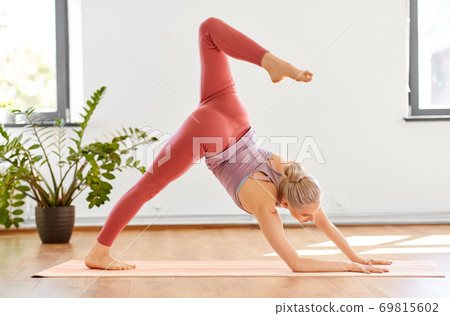 woman does downward-facing dog pose at yoga studio woman does downward-facing dog pose at yoga studio 69815602