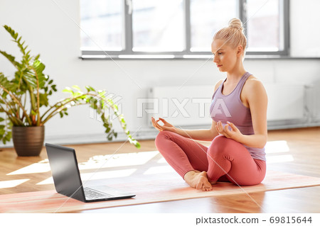 woman with laptop in lotus pose at yoga studio woman with laptop in lotus pose at yoga studio 69815644