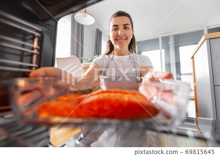 woman cooking food in oven at home kitchen woman cooking food in oven at home kitchen 69815645