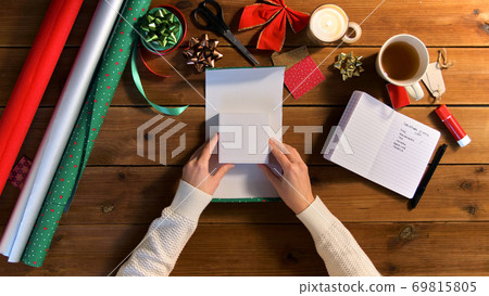 hands wrapping christmas gift into paper at home 69815805