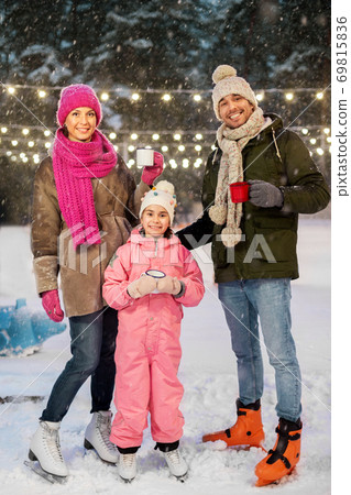 happy family drinking hot tea on skating rink happy family drinking hot tea on skating rink 69815836