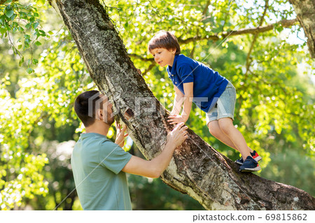 happy father with son climbing tree in summer park 69815862
