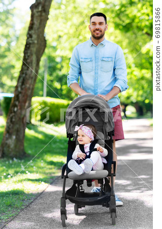 happy father with child in stroller at summer park happy father with child in stroller at summer park 69815866