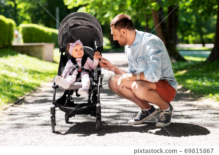 happy father with child in stroller at summer park happy father with child in stroller at summer park 69815867