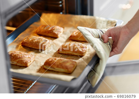 woman cooking food in oven at home kitchen 69816079