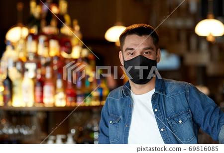 young man in black reusable mask at bar or pub young man in black reusable mask at bar or pub 69816085