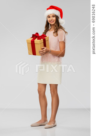 teenage girl in santa hat with christmas gift 69816248