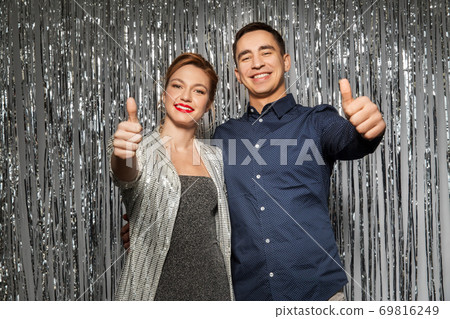 couple in party clothes showing thumbs up 69816249