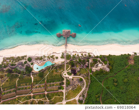 Top View on Beautiful thatch stilt house restaurant and Resort at Zanzibar Kendwa beach at evening time in Turquoise Water of Indian ocean Top View on Beautiful thatch stilt house restaurant and Resort at Zanzibar Kendwa beach at evening time in Turquoise Water of Indian ocean 69818064