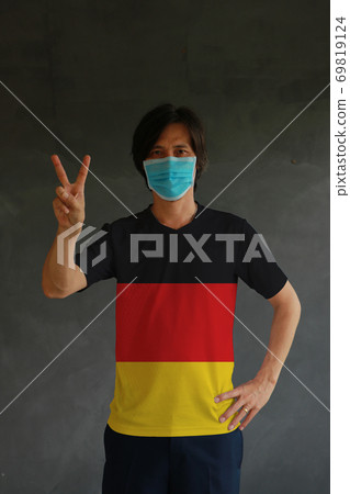 Man wearing hygienic mask and wearing German flag colored shirt Man wearing hygienic mask and wearing German flag colored shirt 69819124