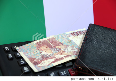 One thousand Lire of Italy banknote with black wallet on the calculator with Italia flag background 69819143