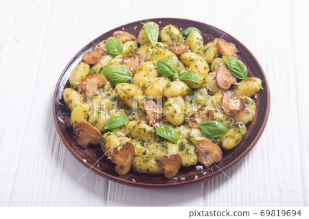 Homemade potatoes gnocchi with basil , cheese and mushrooms Homemade potatoes gnocchi with basil , cheese and mushrooms 69819694