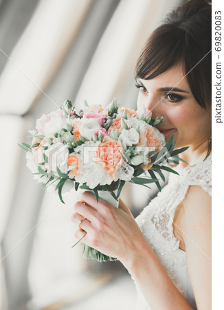 Portrait of stunning bride with long hair posing with great bouquet Portrait of stunning bride with long hair posing with great bouquet 69820083