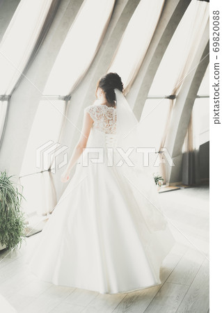 Portrait of stunning bride with long hair posing with great bouquet 69820088
