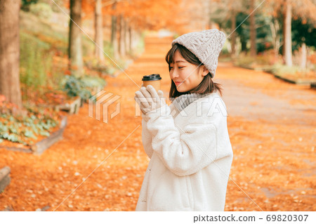 女人在冬季公園喝熱飲料 女人在冬季公園喝熱飲料 69820307