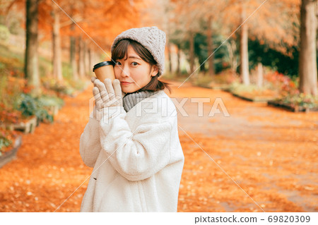 女人在冬季公園喝熱飲料 女人在冬季公園喝熱飲料 69820309