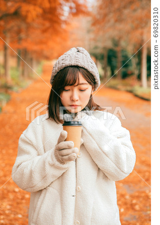 女人在冬季公園喝熱飲料 女人在冬季公園喝熱飲料 69820310