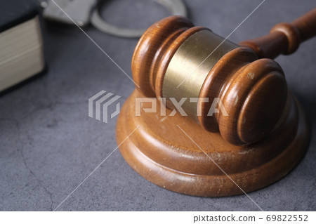 gavel, handcuff and book on table, close up gavel, handcuff and book on table, close up 69822552