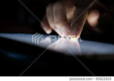 Close up of hacker hand stealing data from digital tablet  69822628