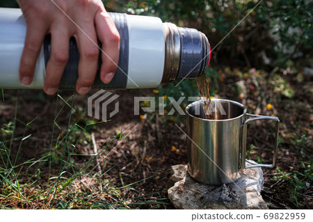 Pouring Hot Tea From Thermos Into Cup Stock Photo - Download Image