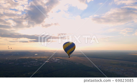 Aerial drone view of colorful hot air balloon flying over green park in small european city at summer sunset Aerial drone view of colorful hot air balloon flying over green park in small european city at summer sunset 69823085