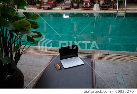 Laptop at the swimming pool and smartphone 69823270
