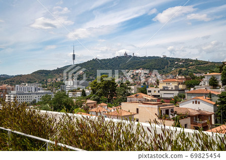 View from a rooftop of typical living area in Barcelona with antenna and mountain at the background. 69825454