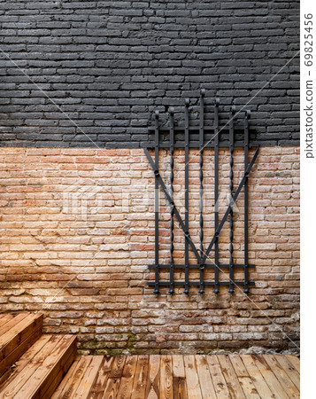 Forged steel metal decorative grille on a brick wall Forged steel metal decorative grille on a brick wall 69825456
